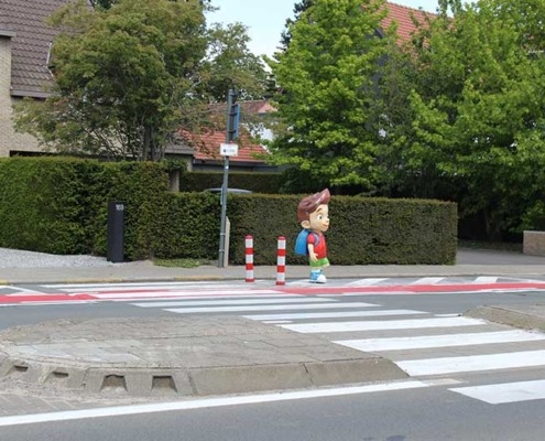 Tom waarschuwt de weggebruikers bij het naderen van een schoolzone